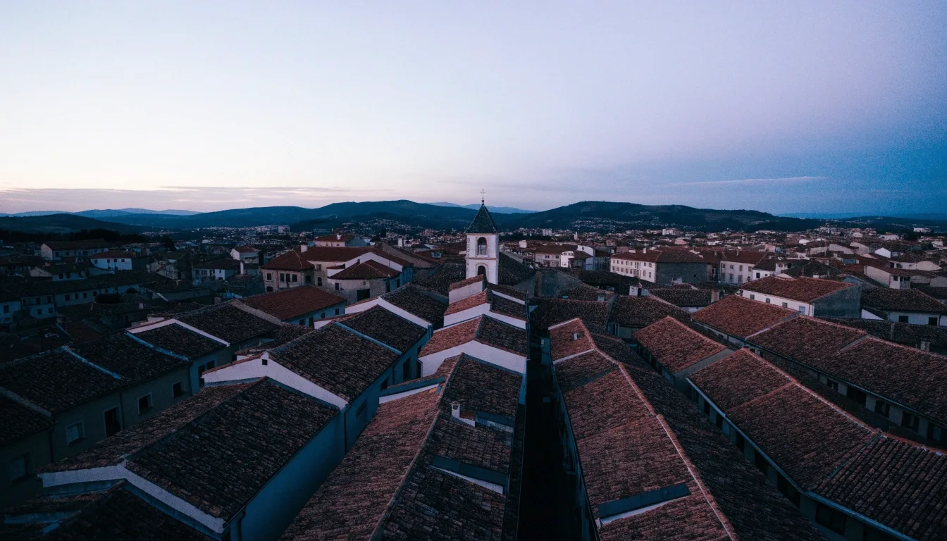 Vista aérea al atardecer sobre una ciudad provincial española con tejados y una torre
